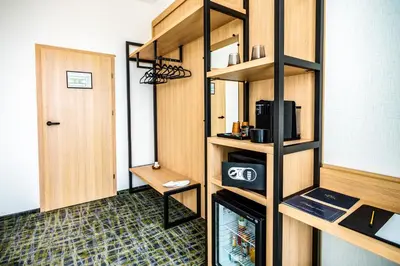 a room with a closet with a microwave and a door at B1 City Hotel Sofia in Sofia