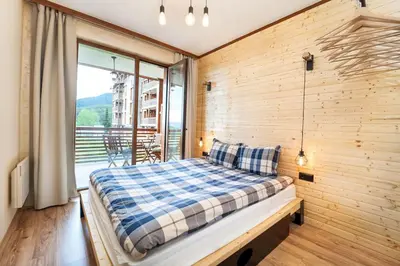 a bedroom with a bed in a wooden wall at Best Mountain View Chalet in Bansko