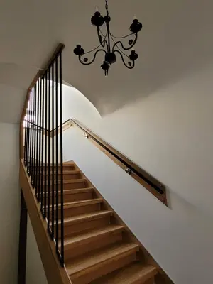 a stairway with a chandelier hanging from a ceiling at The House - Central Boutique Apartments in Kyustendil