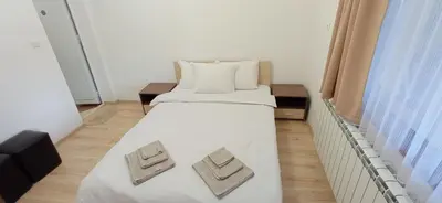 a bedroom with a bed with two towels on it at Къща за гости Джамбазови in Sarnitsa