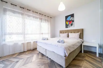 a bedroom with a large bed and a window at Azurro Residence in Sofia