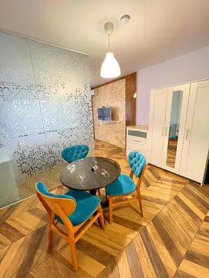 a dining room with a table and chairs and a kitchen at Azurro Residence in Sofia
