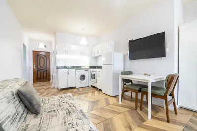 a living room with a bed and a table and a television at Azurro Residence in Sofia