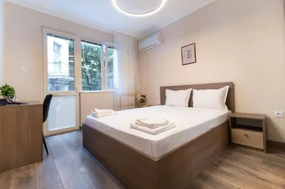 a bedroom with a large bed and a window at Heart of the City 2-Bedroom Apartment in Plovdiv