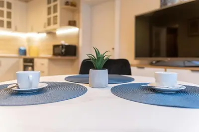 a table with two cups and saucers on it at Heart of the City 2-Bedroom Apartment in Plovdiv