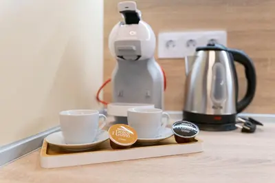 two cups on a tray next to a coffee maker at Heart of the City 2-Bedroom Apartment in Plovdiv