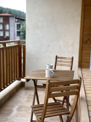 a wooden table and two chairs on a balcony at Katerina Apartments in Velingrad