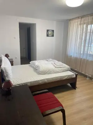 a bedroom with a bed and a table and a window at Kъща за гости Демария in Koprivshtitsa