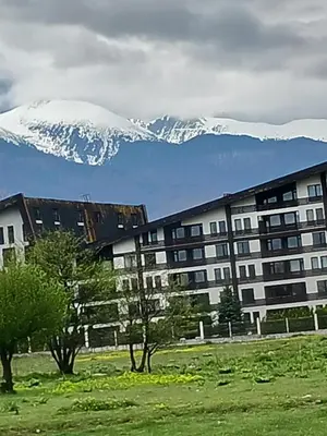 a building with a snow covered mountain in the background at Аспен валей С420 in Razlog