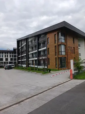 a large brick building with a parking lot at Аспен валей С420 in Razlog
