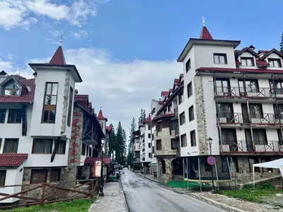 an empty street in a town with tall buildings at Апартамент Касъл in Pamporovo