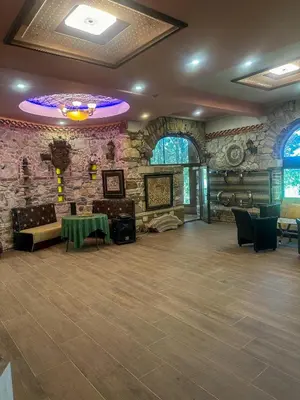 a room with a stone wall with a table and chairs at ТРАКАРТ-ПАРК in Plovdiv