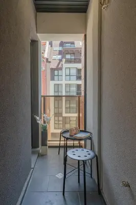 two tables in a room with a large window at Bright Studio in the City Center in Sofia