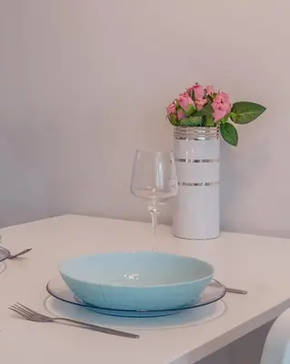 a table with a bowl and a wine glass and flowers at Bright Studio in the City Center in Sofia