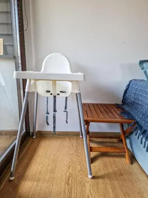 a white chair sitting next to a table in a room at Pastels - 2BD in Trinity Bansko with underground parking by Flat Mаnager in Bansko
