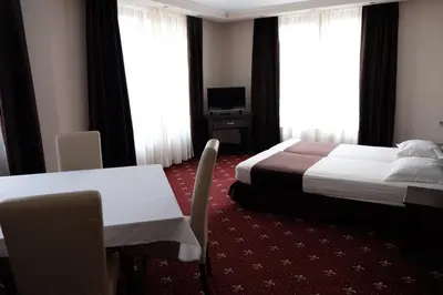 a hotel room with a bed and a table and chairs at Hotel Dragalevtsi in Sofia