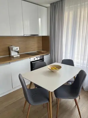 a kitchen with a white table and chairs at Bunaya Sofia in Sofia