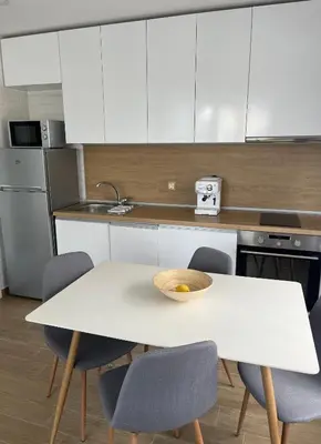a kitchen with a white table and chairs at Bunaya Sofia in Sofia