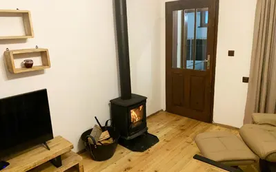 a living room with a wood stove in a room at Къща за гости Константин и Елена - гр. Девин in Devin