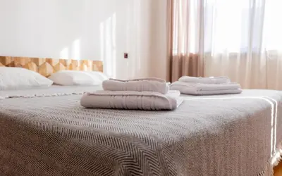 three towels are stacked on top of a bed at Къща за гости Константин и Елена - гр. Девин in Devin