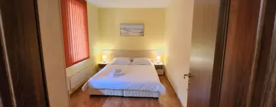 a small bedroom with a bed and two windows at Bojurland, Bansko, Bulgaria in Bansko
