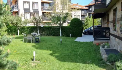 a yard with a table and chairs in the grass at Bojurland, Bansko, Bulgaria in Bansko