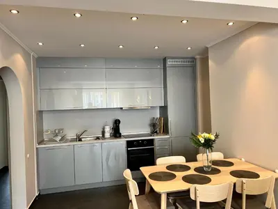 a kitchen with a table and chairs and a kitchen with white cabinets at EXCELLENT LOCATION ! General Gurko apartment in Sofia