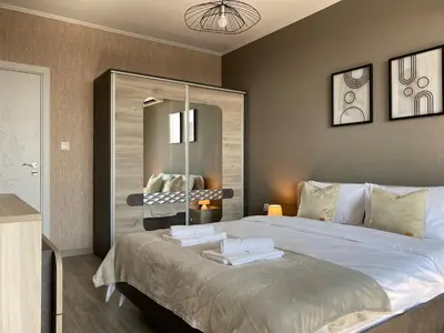 a bedroom with a large bed and a mirror at Private Apartment for 4 Guests and Parking in Plovdiv