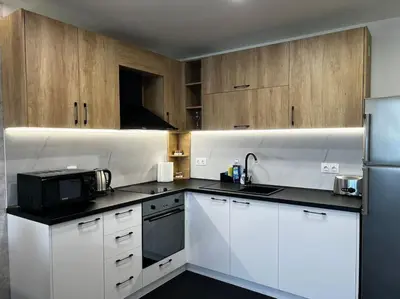 a kitchen with white appliances and wooden cabinets at Blue & Gold Stylish Apartment in Sofia