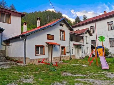 an old house with a playground in front of it at Комплекс Петлето in Smolyan
