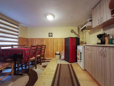 a kitchen with a table and a red refrigerator at Комплекс Петлето in Smolyan