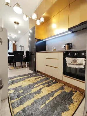 a kitchen with yellow cabinets and a rug on the floor at Gold Infinity in Velingrad
