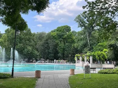 a fountain in a park with people walking around it at 7Mins City Garden and Center+P in Plovdiv