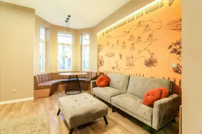 a living room with a couch and a map on the wall at 1 BR Wine Journey in Sofia
