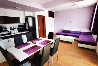 a kitchen and living room with a table and purple chairs at Апартамент 204 Студенец in Pamporovo
