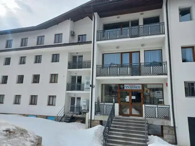 an apartment building with stairs in the snow at Апартамент 204 Студенец in Pamporovo