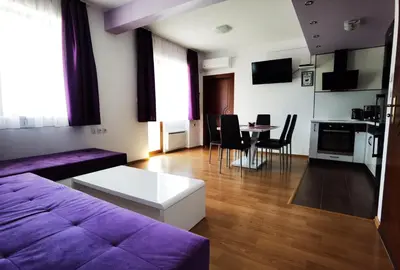 a living room with a purple couch and a table at Апартамент 204 Студенец in Pamporovo
