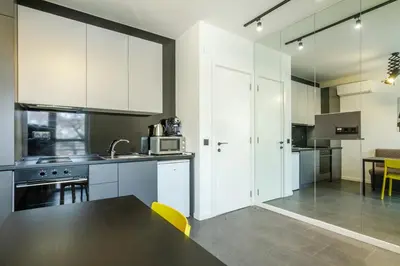 a kitchen with white cabinets and a black counter top at Viral 2 BR Photo Studio Loft in Sofia