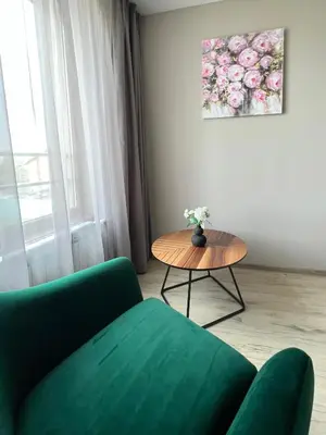 a living room with a green couch and a table at Hotel BLISS Sofia Airport Self Check In in Kazichene