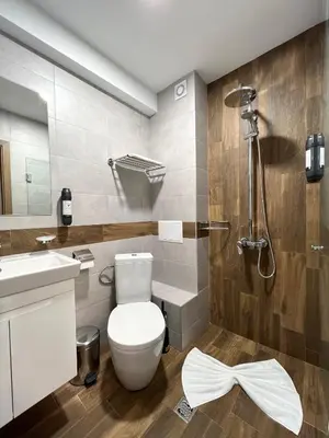a bathroom with a toilet and a sink and a shower at Hotel BLISS Sofia Airport Self Check In in Kazichene