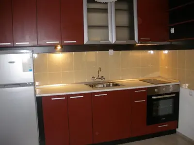 a kitchen with red cabinets and a sink at Fashion Apartments in Sandanski