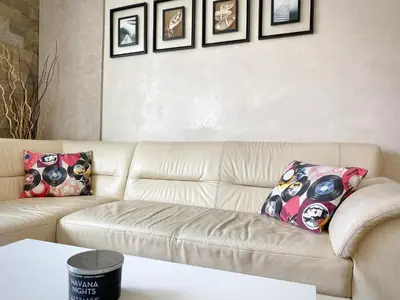 a living room with a white couch with pillows at Entire Apartment for 4 Guests in Sofia in Sofia