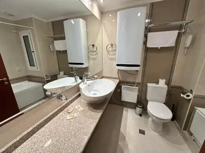 a bathroom with two sinks and a toilet and a tub at Downtown apartments in Bansko