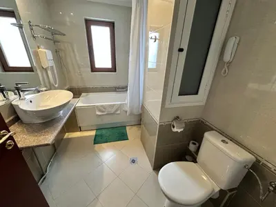 a bathroom with a white toilet and a sink at Downtown apartments in Bansko