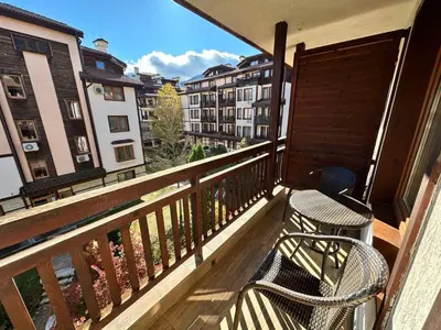 a balcony with a table and chairs on a balcony at Downtown apartments in Bansko