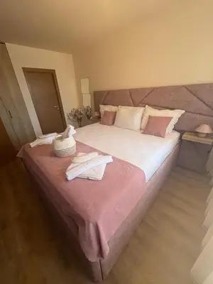 a bedroom with a large bed with a pink blanket at Grand resort luxury apartment in Pamporovo