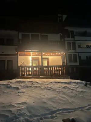 a house with lights on the front of it at night at Grand resort luxury apartment in Pamporovo