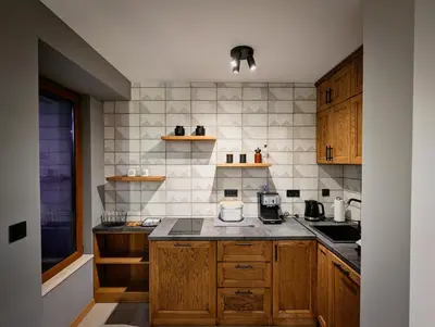 a kitchen with wooden cabinets and a counter top at Pine & Wine Sauna Apartment in Pamporovo