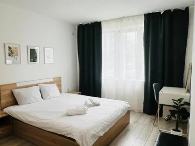 a bedroom with a large bed and a window at Classic Modern Apartment with Parking Place in Sofia