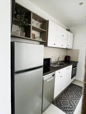 a kitchen with white cabinets and a stainless steel refrigerator at Classic Modern Apartment with Parking Place in Sofia